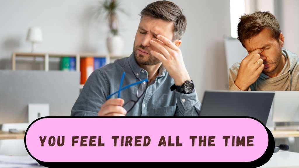 Person sitting slouched on a chair or bed, rubbing their eyes and appearing exhausted, with dark circles under their eyes, indicating constant fatigue.