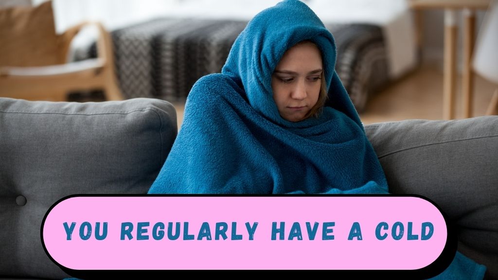 Girl sitting on a couch wrapped in a blanket