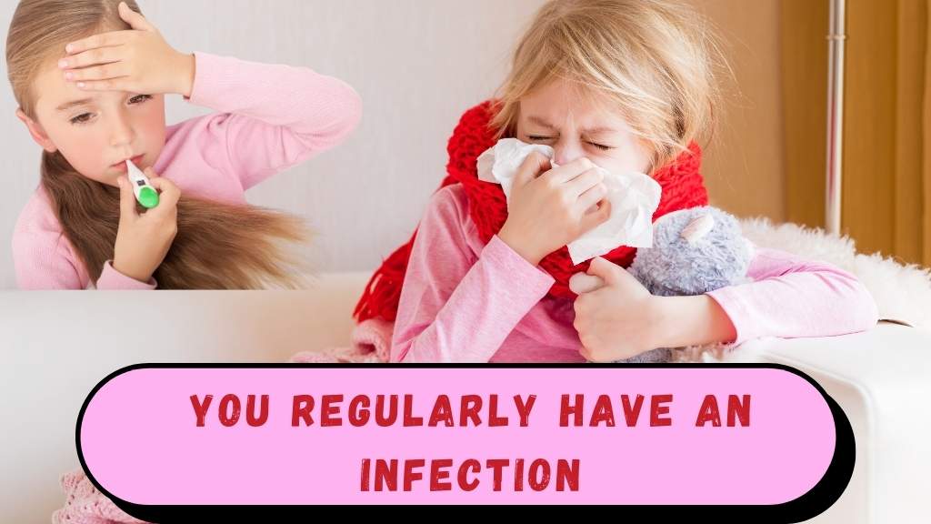 Person sitting in bed looking unwell, with a thermometer in their mouth and medicine bottles on a bedside table, illustrating frequent infections.