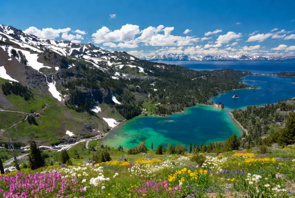 Spring at Lake Tahoe, California – Crystal-clear turquoise waters of Emerald Bay with snow-capped Sierra Nevada mountains in the background